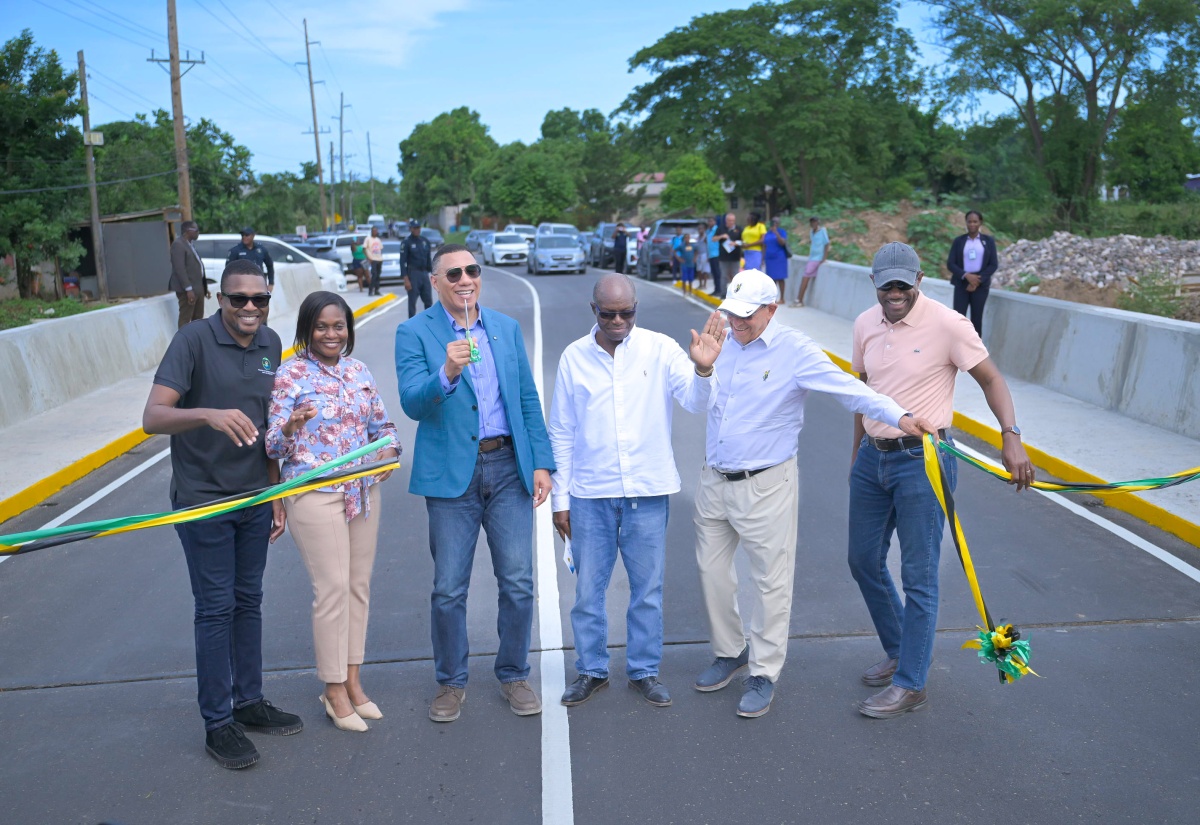 Prime Minister, Dr. the Most Hon. Andrew Holness (third left), cuts the ribbon to mark the recent official opening of the newly constructed bridge in Spring Village, St. Catherine. Sharing in the occasion are (from left) Minister without Portfolio in the Ministry of Economic Growth and Infrastructure Development, Hon. Robert Morgan; Permanent Secretary in the Ministry, Arlene Williams; Member of Parliament, St. Catherine South Western, Everald Warmington; Chairman, Jamaica Broilers Group of Companies, Robert Levy; and Senior Director, National Works Agency (NWA), Varden Downer.  

