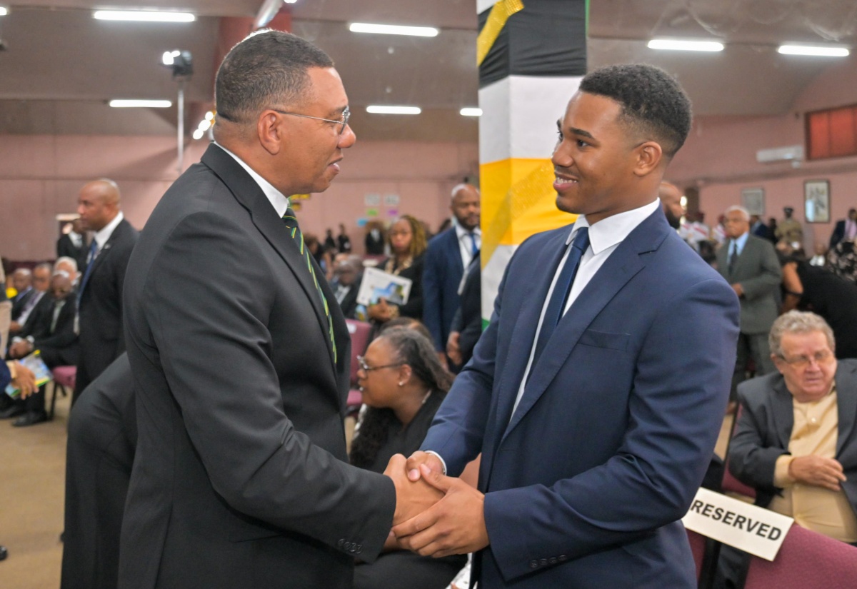 Prime Minister, Dr. the Most Hon. Andrew Holness (left), greets Joshua Campbell, son of late former Government Minister and Parliamentarian, Leslie Roy Campbell, during the Official Funeral Service, held at Fellowship Tabernacle in Kingston on Saturday (June 6).