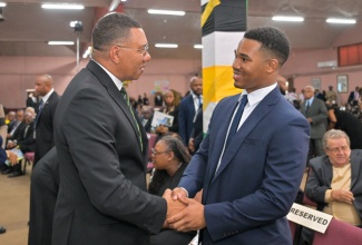 Prime Minister, Dr. the Most Hon. Andrew Holness (left), greets Joshua Campbell, son of late former Government Minister and Parliamentarian, Leslie Roy Campbell, during the Official Funeral Service, held at Fellowship Tabernacle in Kingston on Saturday (June 6).