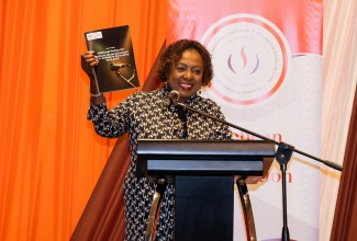 Minister of Culture, Gender, Entertainment and Sport, Hon. Olivia Grange, displays the Green Paper for the National Policy on Culture, Entertainment and the Creative Economy during the 50th  annual conference of the Caribbean Studies Association, held recently at The Jamaica Pegasus hotel in New Kingston.

