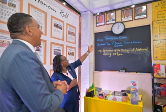 Prime Minister, Dr. the Most Hon. Andrew Holness, listens as Communications Specialist at the Ministry of National Security and Peace, Winsome Christie, showcases features of the Ministry’s booth at the 11th Biennial Jamaica Diaspora Conference at the Montego Bay Convention Centre in St. James on Tuesday (June 16).
