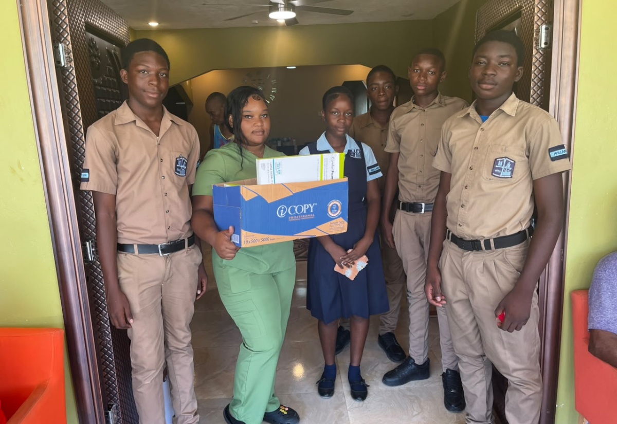 Nursing Home Supervisor, Ashanti Osbourne (second left), at Casa de Amor Nursing Home in Greenwood, St. James, receives donations recently presented by members of the Holland High School Youth Key Club​​​​. 
