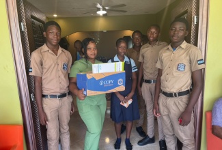 Nursing Home Supervisor, Ashanti Osbourne (second left), at Casa de Amor Nursing Home in Greenwood, St. James, receives donations recently presented by members of the Holland High School Youth Key Club​​​​. 
