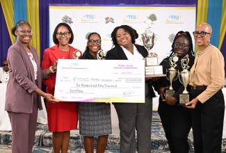 Minister of Finance and the Public Service, Hon. Fayval Williams (right), presents the championship trophy to members of the winning Administrator General’s Department team (from third left) - Jessica Lewis, Merissa Moore, and Quidi-Ann King, during the Grand Finale of the 2026 Public Sector Debate Competition at The Jamaica Pegasus hotel in New Kingston on Thursday (July 9). Sharing in the presentation are Executive Director of the Transformation Implementation Unit (TIU), Maria Thompson Walters (left), and Chief Executive Officer of the Administrator General’s Department, Stacie-Ann Carty.