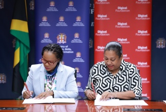 Permanent Secretary in the Ministry of Education, Skills, Youth and Information, Dr. Kasan Troupe (left), and Chief Executive Officer (CEO) of the Digicel Foundation, Charmaine Daniels, sign Memoranda of Understanding (MOU) for the establishment of smart labs at three teachers