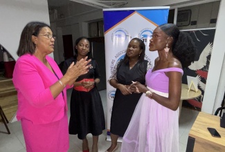 Executive Director, Jamaica Intellectual Property Office (JIPO),  Lilyclaire Bellamy (left),  speaks with entrepreneur, Tashana Mullings (right), following her address at the Young Entrepreneurs Association of Jamaica's  (YEA) Young Entrepreneurs Success Series event on Tuesday (June 30), at The Hub in New Kingston. Listening (from left) are Vice President, YEA, Erika Heslop Martin; and President, YEA, Cordell Williams.
