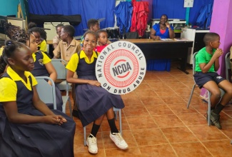 A student proudly displays a National Council on Drug Abuse (NCDA) awareness sign, during an educational session at Golden Grove All-Age School in St. Ann on June 25.
