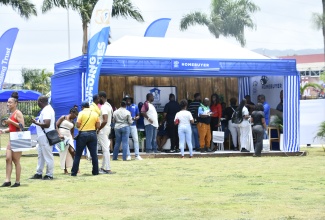 St. James residents gather to speak to representatives from the National Housing Trust (NHT) at the homebuyer booth, during the agency's Home It Expo held at the Harmony Beach Park in St. James on July 3. 
