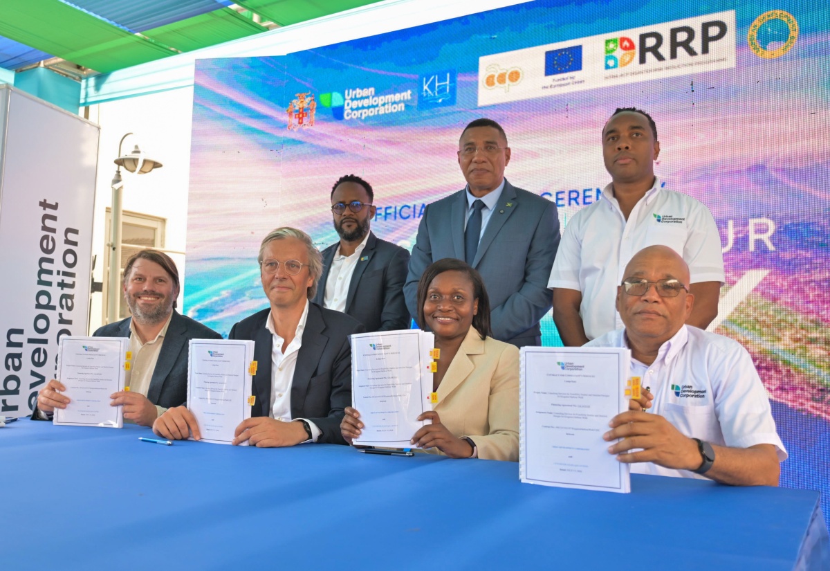 Prime Minister, Dr. the Most Hon. Andrew Holness (standing, centre), participates in the signing of the agreement for consultancy services for segment two of the Kingston Harbour Walk Project at the Carib Cement Sports Club and Wellness Centre in Rockfort, Kingston, on Wednesday (July 22). He is joined by Representative, Caribbean Development Bank (CDB), Dr. Oronde Small (standing, left) and Urban Development Corporation (UDC) General Manager, Robert Honeyghan (standing right). Displaying copies of the signed agreement (from left) are consultants Co-founder of Felixx Landscape Architects and Planners, Michiel Van Driessche, and founder of Cityförster, Martin Sobota;  Permanent Secretary in the Ministry of Economic Growth and Infrastructure Development, Arlene Williams; and (UDC) Chairman, Norman Brown. 

