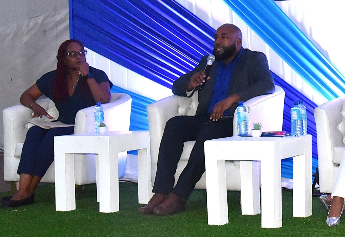 Director of Intake, Investigation, Court and Adoption at the Child Protection and Family Services Agency (CPFSA), Dr. Warren Thompson (right), addresses a recent panel discussion at the World Day Against Trafficking in Persons Town Hall Forum, held at Emancipation Park in St. Andrew. Pictured at left is Clinical Psychologist at the Ministry of Justice and Constitutional Affairs, Leah Miles.