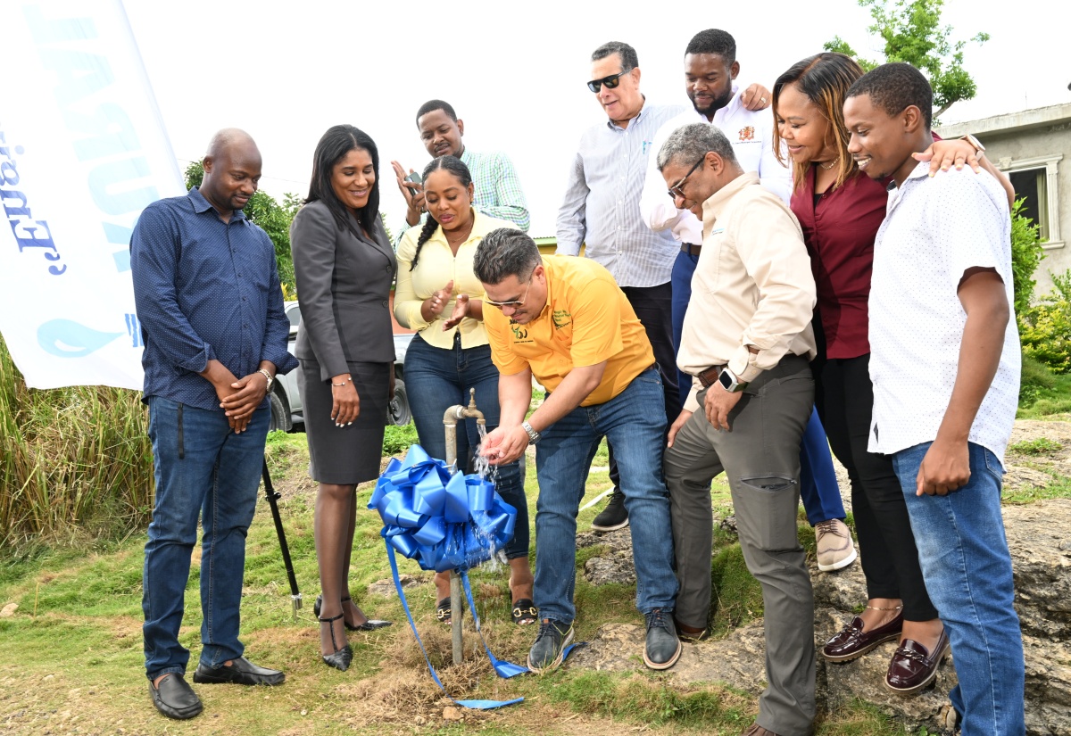 Minister of Water, Environment and Climate Change, Hon. Matthew Samuda (centre), turns on a pipe to officially commission the Spring Garden Water Supply System in St. James on Wednesday (August 19). Looking on are Mayor of Montego Bay and Chairman of the St. James Municipal Corporation Councillor Richard Vernon (left); Chief Executive Officer of the St. James Municipal Corporation, Naudia Crosskill (second left); Member of Parliament (MP) for St James Southern Nekeisha Burchell (third left); former MP, Homer Davis (fourth right); and other stakeholders.
