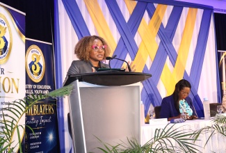 Minister of Education, Skills, Youth and Information, Senator Dr. the Hon. Dana Morris Dixon (at podium), addresses the Ministry's Region Three Back-To-School Leadership Summit for Principals and School Board Chairs at Ocean Coral Spring Resort in Coral Spring, Trelawny, on Tuesday (August 11). Seated is Acting Chief Education Officer in the Ministry, Terry-Ann Thomas Gayle.
