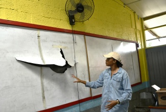 Minister of State in the Ministry of Education, Skills, Youth and Information, Hon. Rhoda Moy Crawford, shows one of the damaged whiteboards at Albert Town Primary and Infant School in Trelawny, which will be replaced as part of repairs now taking place at the school. She was visiting the school on Thursday (August 13) to assess ongoing repairs. 
