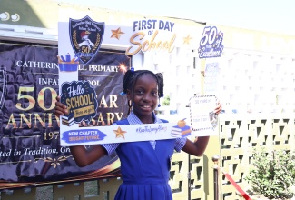 Grade-four student at Catherine Hall Primary and Infant School in St. James, Emelia Erskins, enjoys a moment with a commemorative photo frame on the first day of the 2026/27 academic year on Monday (September 7). The school officially launched its 50th-anniversary celebrations on the campus the same day.
