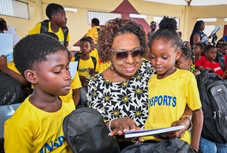 Minister of Culture, Gender, Entertainment and Sport, Hon. Olivia Grange, interacts with participants in the Institute of Sports (INSPORTS) Summer Youth Camp 2026, Allan Parkes (left) and Alliandrea Morris, during the camp's recent Closing and Awards Ceremony at Eltham High School in St. Catherine.
