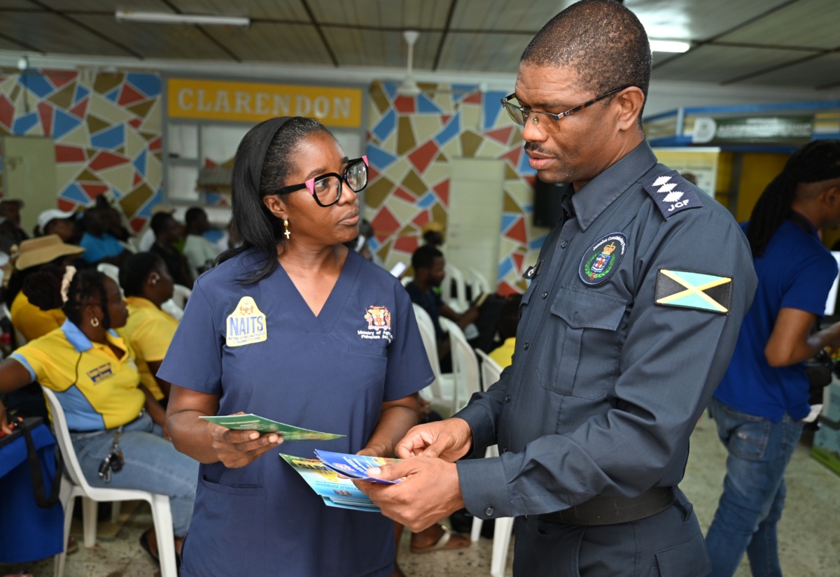 Senior Animal Health Technician at the Veterinary Services Division, Sharna Frater (left), and Commander for Area 3 Agricultural Protection Branch (APB) of the JCF, Deputy Superintendent Tedroy Clarke, in conversation during the recent Clarendon Praedial Larceny Farmer Sensitisation Meeting, at the Denbigh Showground.
