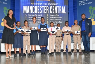 State Minister in the Ministry of Education, Skills, Youth and Information and Member of Parliament for Manchester Central, Hon. Rhoda Moy Crawford, shares photo opportunity with students from her constituency as they display tablets received during the Universal Service Fund (USF) Connect-a-Child Awards Ceremony, held on August 28 at the Karl Hendrickson Auditorium at Jamaica College in St. Andrew. Joining them is USF Chief Executive Officer, Charlton McFarlane.

