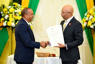 Governor-General, His Excellency the Most Hon. Sir Patrick Allen (right), presents new Custos Rotulorum for St. Elizabeth, Hon. Bernard Henry, with his Instrument of Appointment during a swearing-in ceremony at King's House on Thursday (October 15).
