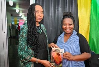 Senior Director at the National Gallery of Jamaica, Dr. Nadine Boothe-Gooden (left), joins author and philanthropist, Dawn Smikle, in displaying her book titled 'Grace Beyond Brokeness', during Sunday's (October 11) Legal Deposit Day Celebration at the Ministry of Culture, Gender, Entertainment and Sport in New Kingston.  Dr. Boothe-Gooden represented portfolio Minister, Hon. Olivia Grange.
