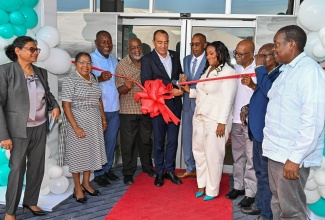 Minister of Health and Wellness, Dr. the Hon. Christopher Tufton (fifth left), cuts the ribbon to officially open the Tensie Mae Robinson (TMR) Medical Limited in Portmore, St. Catherine, on Wednesday (October 7). He is joined by (from left) Chief Medical Officer (CMO) of Jamaica, Dr. Jacquiline Bisasor-McKenzie; Custos of St. Catherine, Hon. Icylin Golding; Mayor of Portmore, Councillor Leon Thomas; Member of Parliament for South St. Catherine, Fitz Jackson; TMR Medical Limited Board Chairman, Dwight Robinson; Chief Executive Officer of TMR Medical Limited, Deidre Ann Dennis; Medical Director at TMR Medical Limited, Dr. Morais Guy, Managing Director of Dwight’s Construction, Benton Woodbine; and Minister without Portfolio in the Ministry of Economic Growth and Infrastructure Development with responsibility for Land Titling and Settlements, Hon. Robert Montague.
