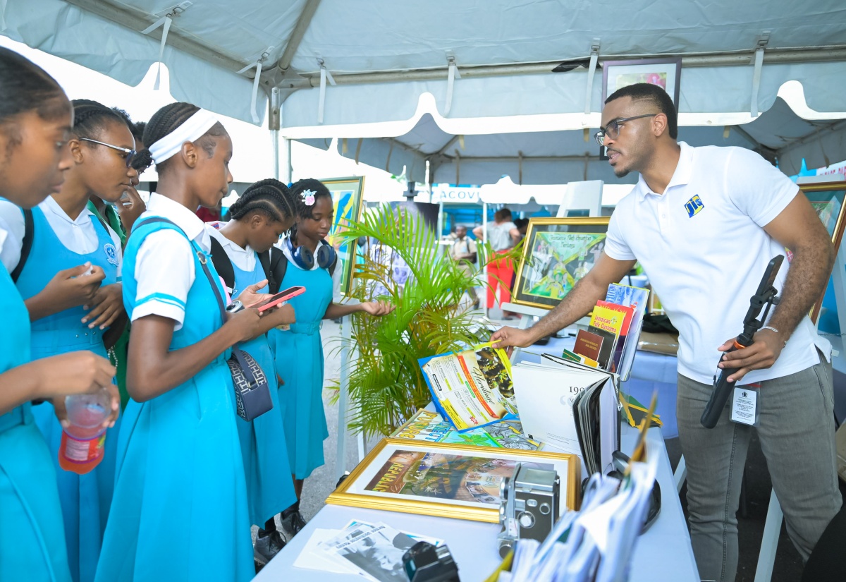 Students of Lacovia High School visit the Jamaica Information Service (JIS) exhibition booth during a Visual Arts Symposium hosted by the school in partnership with Studio Mortimer Limited. Special Projects Manager, Paul Allen, shared information on the agency’s 2026 Heritage Competition and highlighted opportunities for young creatives to showcase their talents.

