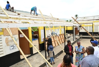 Parliamentary Secretary in the Ministry of Education, Skills, Youth and Information, Senator Marlon Morgan (right), and stakeholders observe repair work under way at the Burnt Savannah Primary and Infant School in St. Elizabeth, prior to the reopening of school in September.
