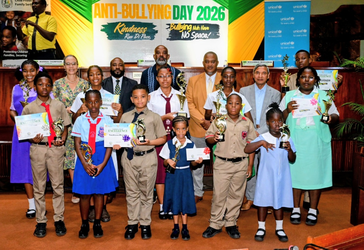 National Coordinator for Safety and Security in Schools, Richard Troupe (back row, second left), joins top performers in the National Anti-Bullying poster competition as they display their certificates and trophies. The occasion was the National Anti-Bullying Day Forum at the Jamaica Conference Centre in downtown Kingston on Wednesday (October 7). Also sharing the moment are Chairman of the Advisory Board, Child Protection and Family Services Agency (CPFSA), Dr. Diana Thorburn (back row, second left); Acting Chief Executive Officer, CPFSA, Dr. Warren Thompson (back row, third left); and President, National Parent-Teacher Association of Jamaica, Stewart Jacobs (third row, centre).
