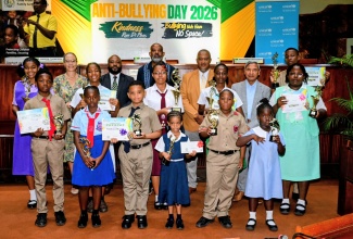 National Coordinator for Safety and Security in Schools, Richard Troupe (back row, second left), joins top performers in the National Anti-Bullying poster competition as they display their certificates and trophies. The occasion was the National Anti-Bullying Day Forum at the Jamaica Conference Centre in downtown Kingston on Wednesday (October 7). Also sharing the moment are Chairman of the Advisory Board, Child Protection and Family Services Agency (CPFSA), Dr. Diana Thorburn (back row, second left); Acting Chief Executive Officer, CPFSA, Dr. Warren Thompson (back row, third left); and President, National Parent-Teacher Association of Jamaica, Stewart Jacobs (third row, centre).
