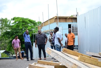 Parliamentary Secretary in the Ministry of Education, Skills, Youth and Information, Senator Marlon Morgan (third left), listens as Acting Principal of Knox College, Omar Smith, outlines the progress of post-Hurricane Melissa restoration work, during a visit to the institution in Clarendon on Thursday (October 8). Looking on are Regional Director for Region 7, Barrington Richardson, and other stakeholders. 
