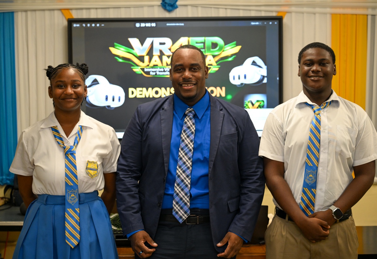 Business and Information Technology Teacher at Seaforth High School, Terron Strachan (centre), shares a photo moment with students Ramona Williams (left) and Jevonte Hamilton at the school in St. Thomas.
