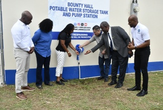 Minister of Water, Environment and Climate Change, Hon. Matthew Samuda (third right), turns on a tap to officially commission the upgraded Bounty Hall Water System in Trelawny on October 8. Joining him are (from left) National Water Commission (NWC) Regional Manager for Trelawny and St. James, Herman Fagan; Acting Vice President of Operations at the NWC, Philippa Campbell-Francis; Deputy Mayor of Falmouth and Councillor for the Wakefield Division, Jonathan Bartley; and Permanent Secretary in the Ministry of Water, Environment and Climate Change, Wayne O. Robertson. The system forms part of the Belfield Well Rehabilitation and Bounty Hall System Upgrade Project
