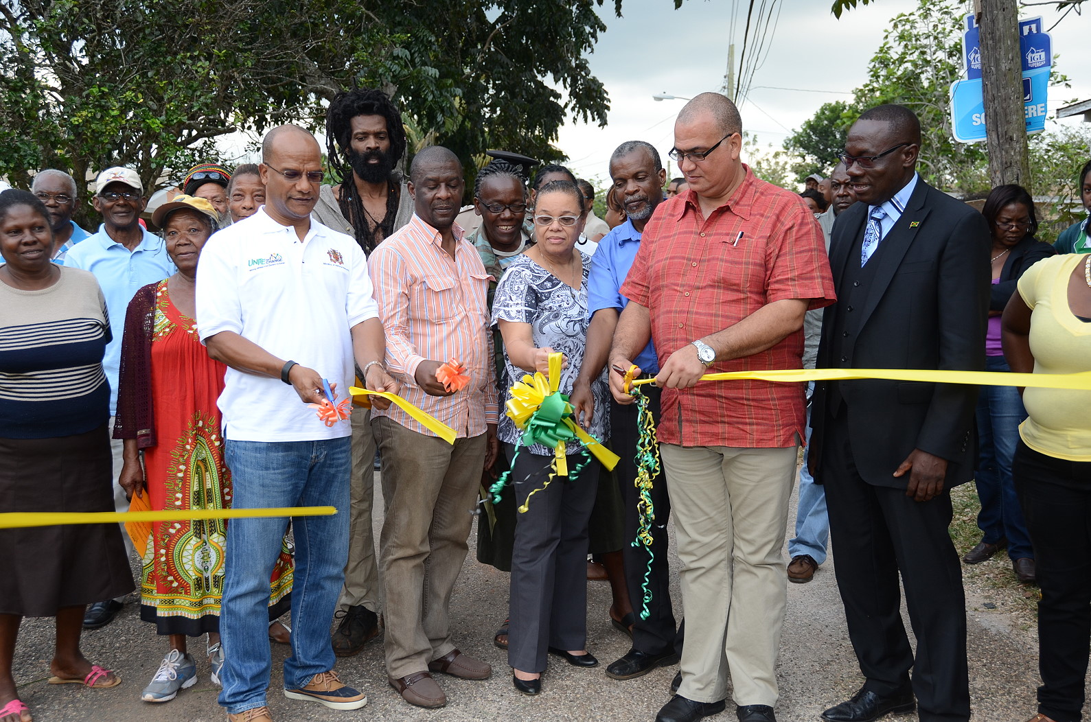 National Security Minister and Central Manchester Member of Parliament, Hon. Peter Bunting (left, foreground), and State Minister for Transport, Works, and Housing, Hon. Richard Azan (second right, foreground), cut the ribbon to symbolise the official opening of the newly refurbished Woodlawn Crescent road in Royal Flat, Manchester during a ceremony at that location on February 13. The road was repaired at a cost of $2.6 million under phase three of the Jamaica Emergency Employment Programme  (JEEP). The corridor is one of two in the constituency which were repaired at an overall cost of $6.2 million under JEEP, the other being Bashie Road in Bellefield. Also participating in the formalities (from second left, foreground) are: Councillor, Royal Flat Division, Donovan Mitchell; Mayor of Mandeville,  Councillor Brenda Ramsay; Councillor, Mandeville Division, Jones Oliphant; and Vice President, Spiritual Affairs, Northern Caribbean University (NCU), Senior Pastor Michael Harvey.