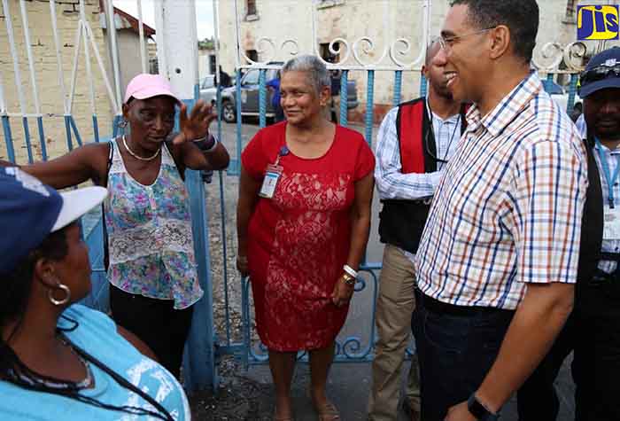 Prime Minister, the Most Hon. Andrew Holness, interacts with residents during a tour of sections of Montego Bay on January 27. At centre is Public Defender,  Arlene Harrison Henry. 