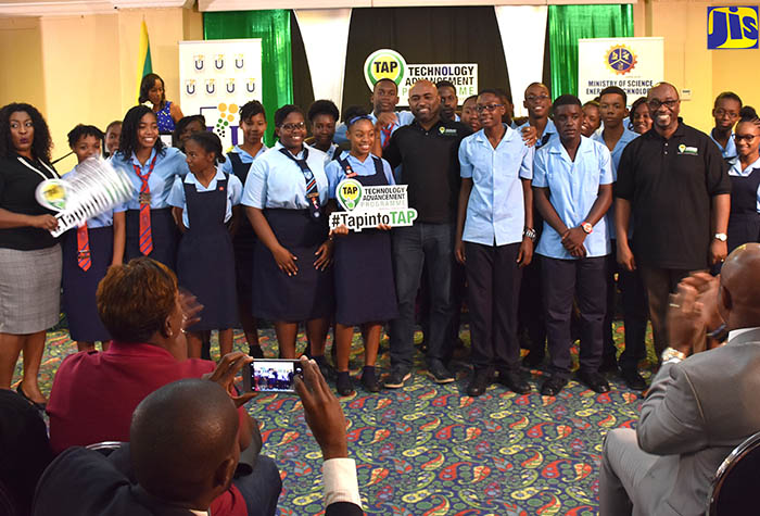 Minister of Science, Energy and Technology, Hon. Andrew Wheatley (centre); Chairman of the Universal Service Fund (USF), Robert Lawrence (fourth right, front row); and Chief Executive Officer, Suzette Buchanan (left, front row) with the All Together Sing 2017 Champion, Knox High School Choir, during a performance following the launch of the USF’s Technology Advancement Programme (TAP) at The Knutsford Court Hotel in Kingston on December 15.
