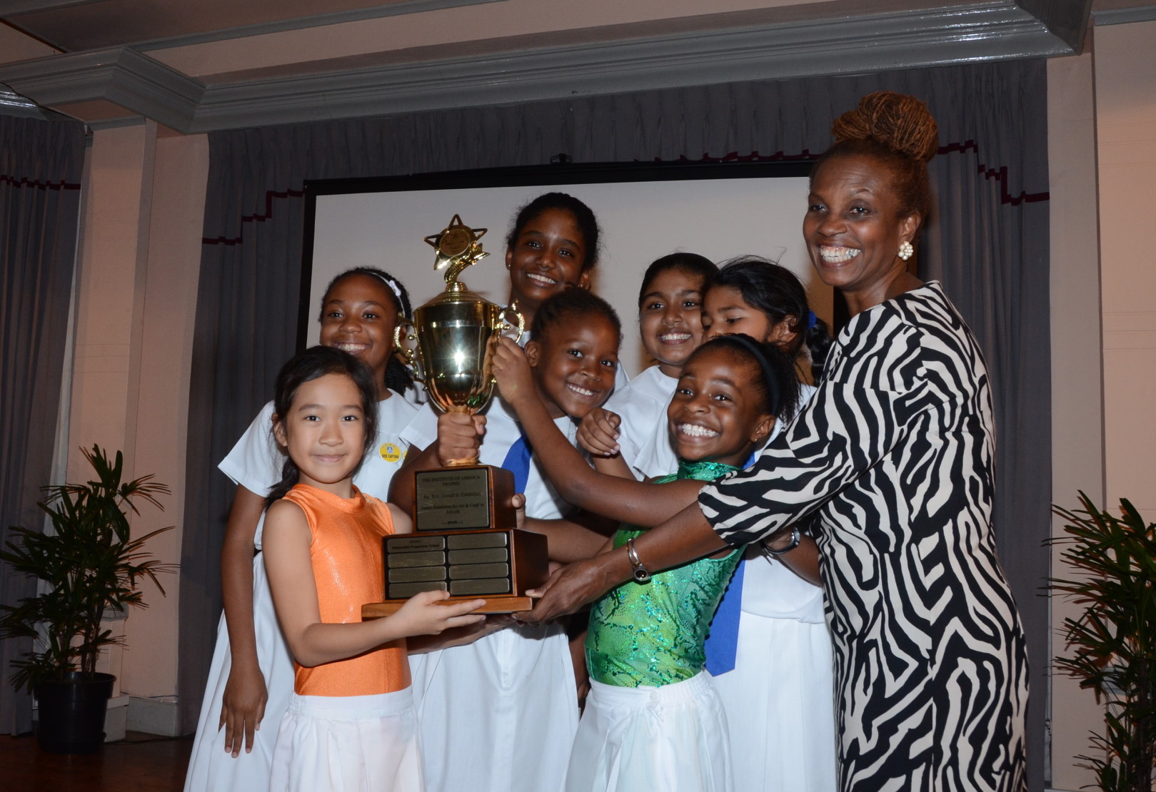 Students of the Immaculate Conception Preparatory School accept the trophy for Best Overall Exhibition in the Junior Exhibition for Art and Craft in Schools Competition, from Executive Director of the Institute of Jamaica (IOJ), Ann Marie Bonner (right). The awards ceremony was held  recently at the Institute of Jamaica, downtown Kingston.