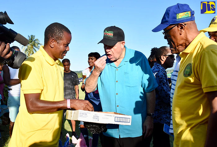 Minister of Industry, Commerce, Agriculture and Fisheries,  Hon. Audley Shaw (centre), tastes shredded coconut at the St. Mary Agricultural Show at Gray’s Inn Sports complex, on Monday (April 2). Others (from left) are Highgate Senior Citizens Club member, Louis Chambers; and President of the club, Robert Osbourne.   The club designed and manufactured the electronic coconut shredder, which was on display at the event. 


