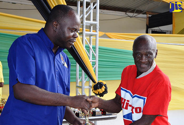 Principal Director in the Ministry of Industry, Commerce, Agriculture and Fisheries, Shaun Baugh (left), presents trophy to  the Champion Cattle farmer at the 2017 Hague Agricultural and Livestock show, Carlton Smith. The presentation took place on March 1 during the opening ceremony for the annual event in Hague, Trelawny.