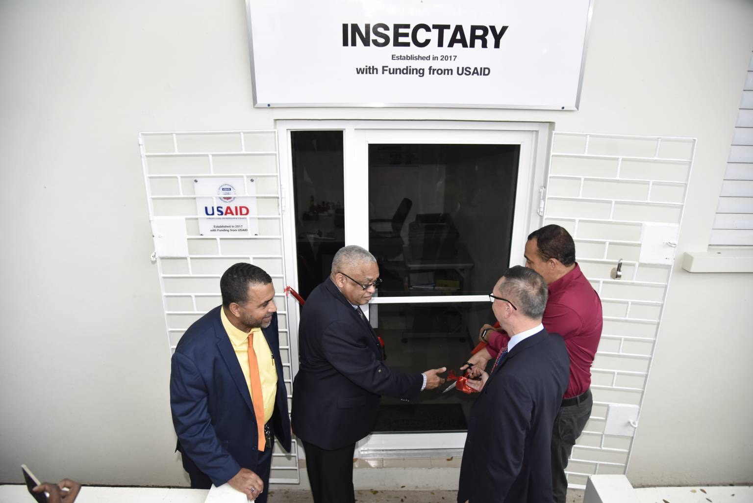 Health Minister, Dr. the Hon. Christopher Tufton (right), officially opens the Mosquito Control and Research Unit (MCRU) Insectary at the University of the West Indies (UWI), Mona Campus, recently. Assisting him are UWI Pro Vice-Chancellor and Mona Campus Principal, Professor Archibald McDonald (second left), and Chargé d’Affaires at the United States Embassy in Jamaica, Eric Khant (second right).  At left is Chief Medical Officer in the Health Ministry, Dr. Winston De La Haye.  