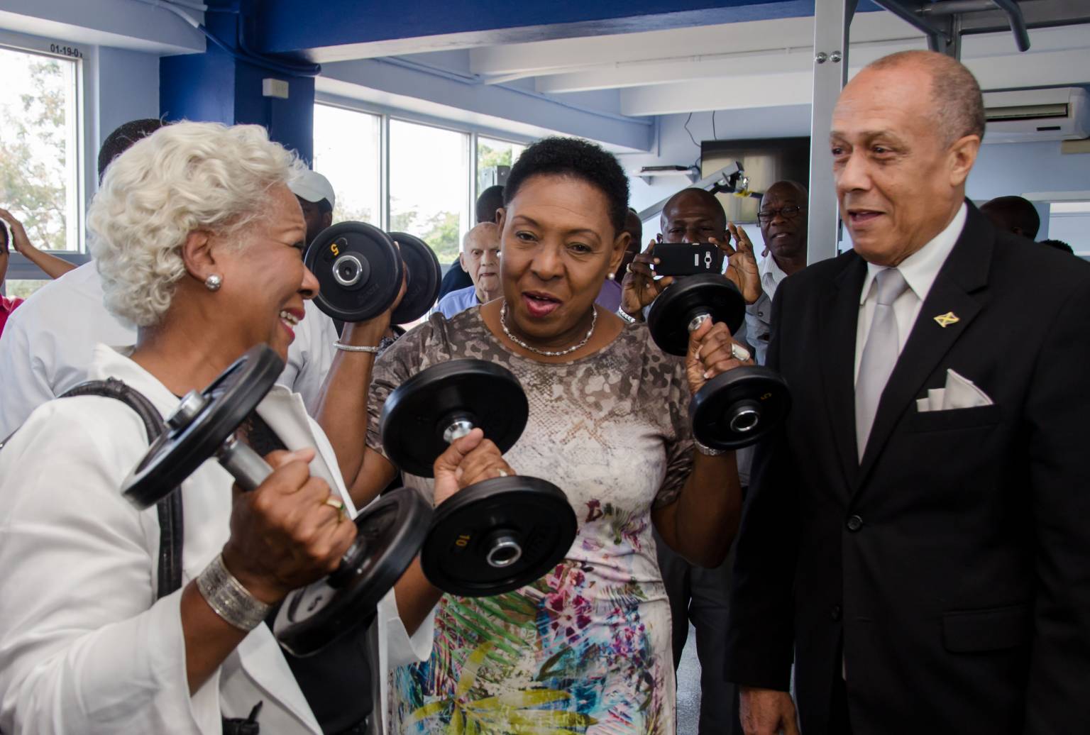 Minister of Entertainment, Sport, Culture and  Gender Affairs, Hon. Olivia ‘Babsy’ Grange  (centre), tries out the weights at the National Health Fund/Jamaica Cricket Association (JCA) wellness centre, which was officially opened at  Sabina Park,  today (March 17).  Others (from left) are:  Project Manager, Culture, Health, Arts, Sports and Education (CHASE) Fund, Paulette Mitchell and former national football player, Ali McNab.