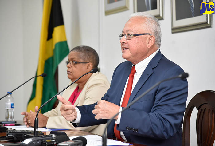 Justice Minister, Hon. Delroy Chuck (right), addresses a press conference at his Constant Spring Road offices in St. Andrew on December 13. At left is Permanent Secretary in the Ministry, Carol Palmer.