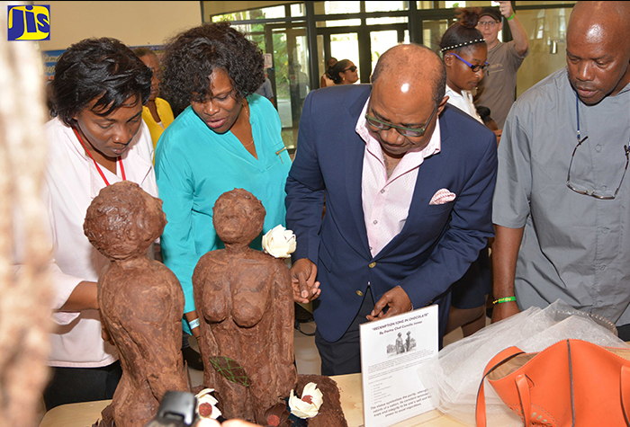 ) Minister of Tourism, Hon. Edmund Bartlett (second left) and Principal of HEART Trust/NTA, Dr. Janet Dyer (right), share lens time with  future chefs who were among hundreds of high-school students attending the Tourism Enhancement Fund (TEF) Taste of Jamaica competition and expo at the Montego Bay Convention Centre on Saturday, December 2. The students are (from left): Asha Muwwaail, Rochelle Frater and Shanique Freeman. 