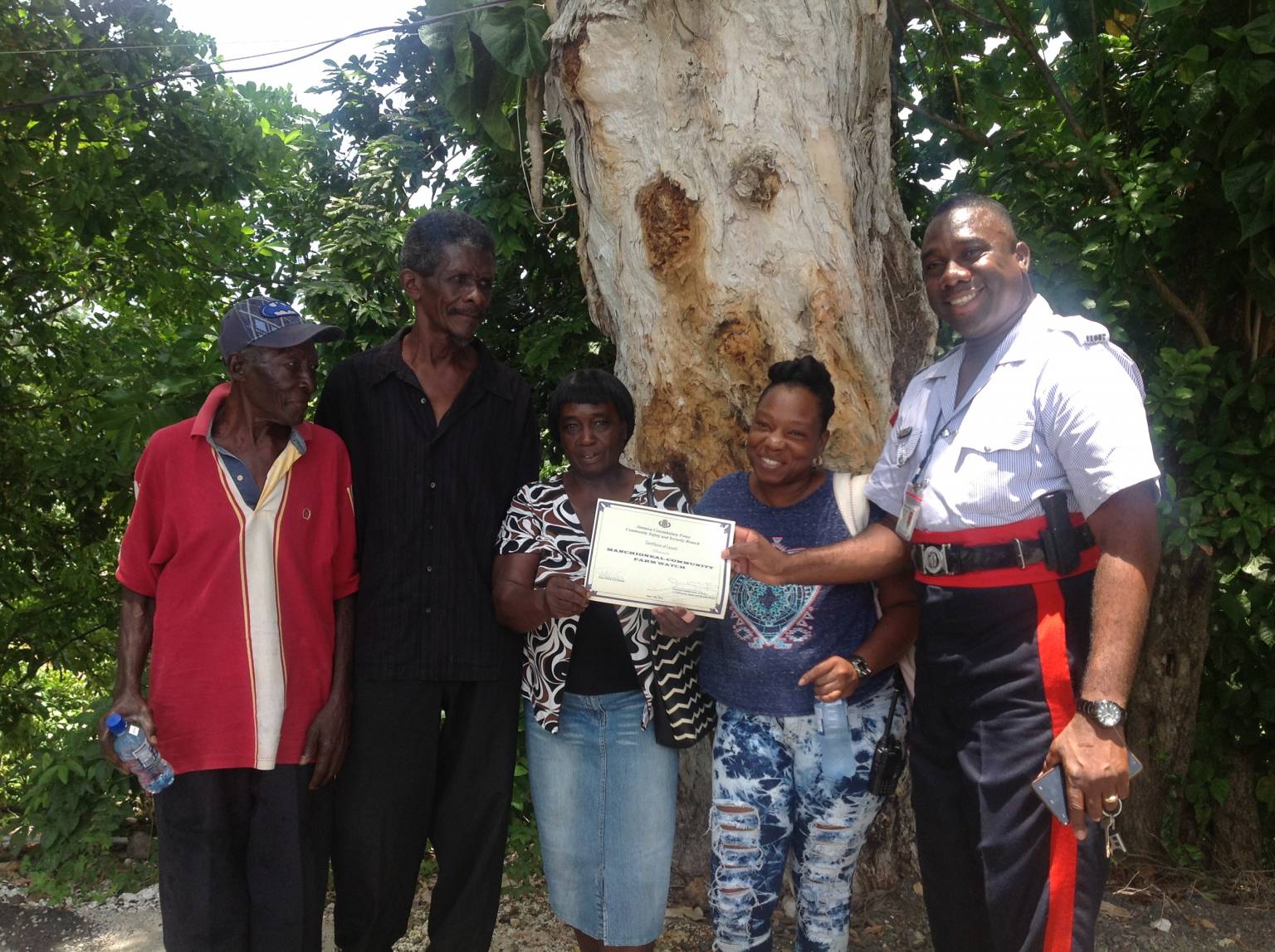Coordinator for the Farm Watch Programme, Sergeant Maurice McLean (right),  presents a certificate to residents of the Manchioneal Farm Watch at the launch on June 17, at the Rural Agricultural Development Authority (RADA) office at Folly Road in Port Antonio, Portland. 
