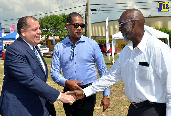 Minister of Finance and the Public Service, Hon. Audley Shaw (left), is greeted by Managing Director, Factories Corporation of Jamaica (FCJ), Donald Farquharson (right), as he arrives at the Garmex Free Zone and Industrial Estate, Marcus Garvey Drive, on Wednesday (October 18) for the FCJ’s business and wellness expo.  At centre is Chairman, FCJ,  Lyttleton Shirley.