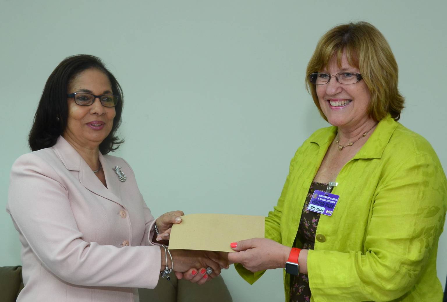 Minister of Labour and Social Security, Hon. Shahine Robinson (left),  accepts a cheque valued at $250,000  from Katherine Grandy, of Gebbers Farms, in Washington, when  operators of the  holdings visited the Ministry, today (April 27). The money will be handed over to a charitable organisation.