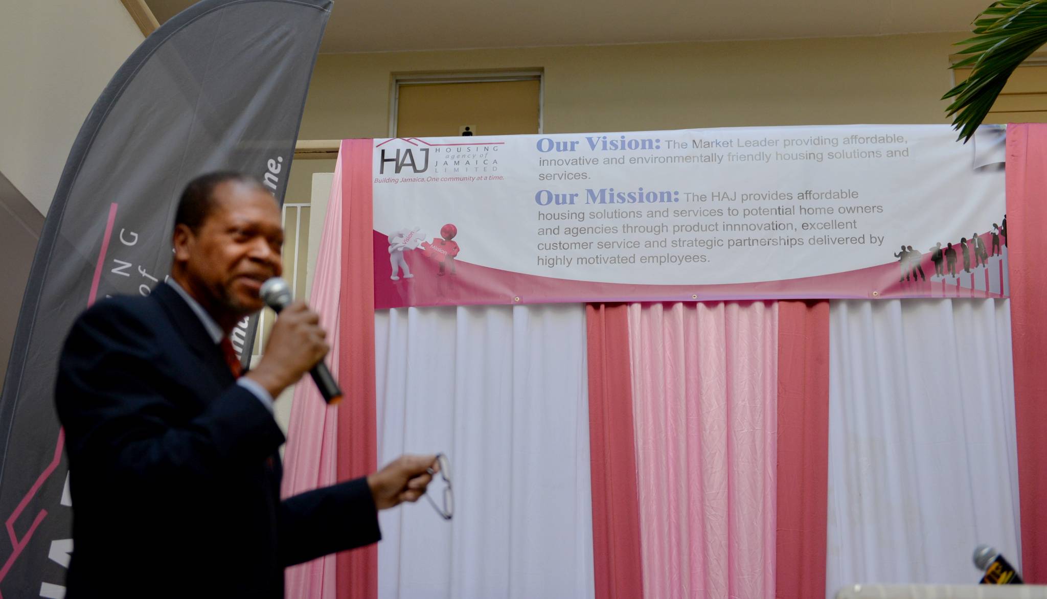 Managing Director of the Housing Agency of Jamaica (HAJ), Karl Bennett (left), points to the agency’s new vision and mission statements, at a special launching ceremony today (November 3), at the company’s head offices on Caledonia Avenue, Kingston.
The new statements will guide the future operation of the company and its approach to its internal and external customers.  