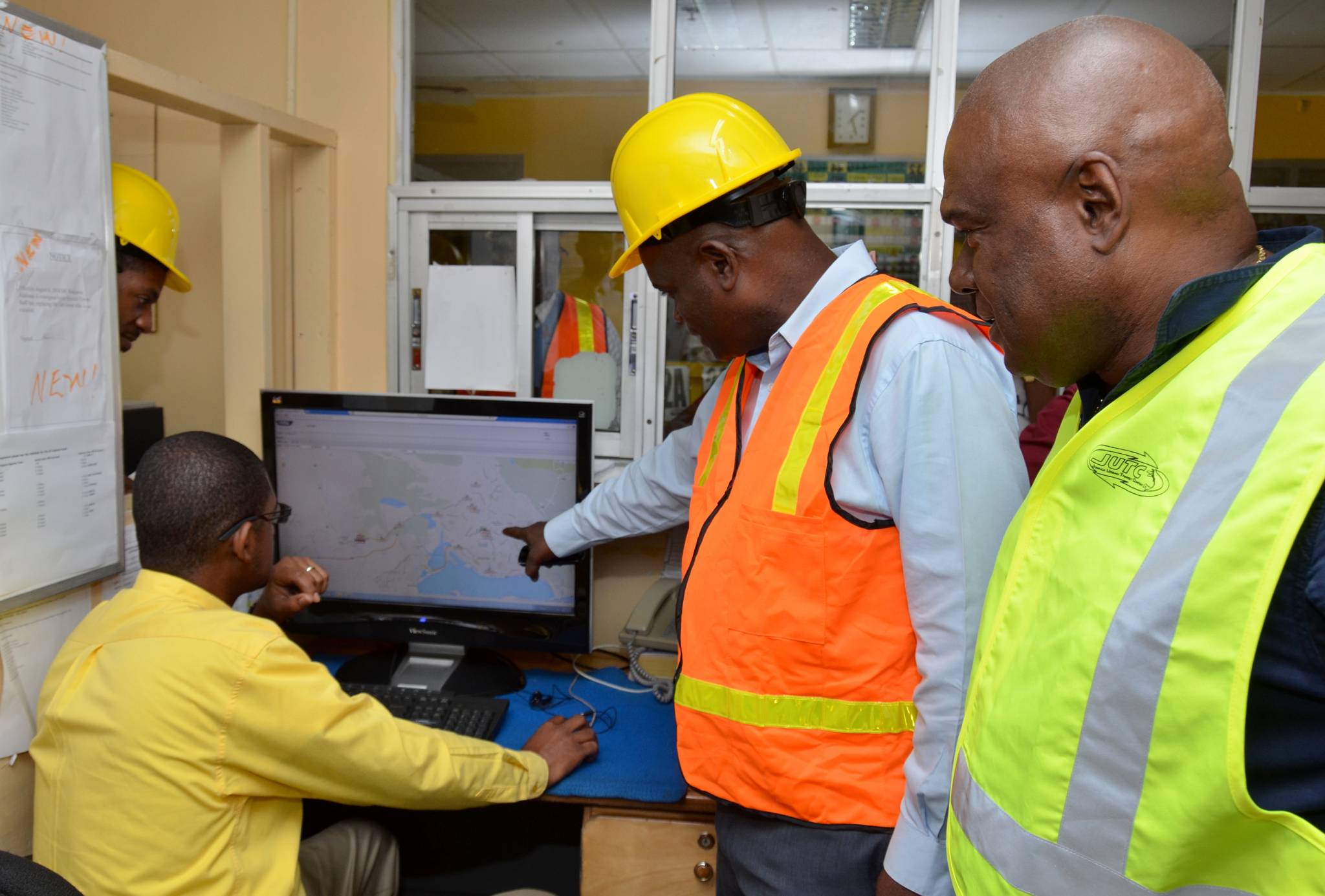 Managing Director of the Jamaica Urban Transit Company (JUTC), Colin Campbell (right), looks on as Manager of the JUTC