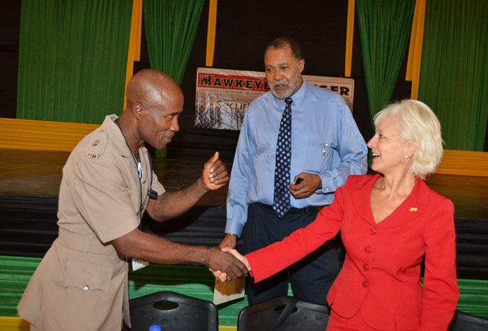 Senior Superintendent of Police (SSP) in charge of the Montego Bay Police, SSP Parkins (left), exchanges pleasantries with President and Chief Executive Officer of the Jamaica Public Service Company (JPSCo) Limited, Kelly Tomblin, shortly before addressing the Montego Bay Chamber of Commerce and Industry's Pre-Christmas Public Forum held on December 11 at the Montego Bay Civic Centre, St. James.  Looking on is President of the Chamber, Nathan Robb.