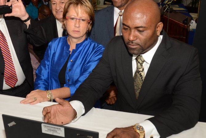 Minister of Science, Energy and Technology (MSET), Dr. the Hon. Andrew Wheatley (right), uses a laptop to access the Open Data Portal at its launch on June 24, at the Petroleum Corporation of Jamaica (PCJ), in Kingston. Country Manager of the World Bank, Galina Sotirova (left), looks on. In the background (from left) are: Chief Information Officer in the Ministry, Louis Shallal and Director, Technology, Gary Campbell.