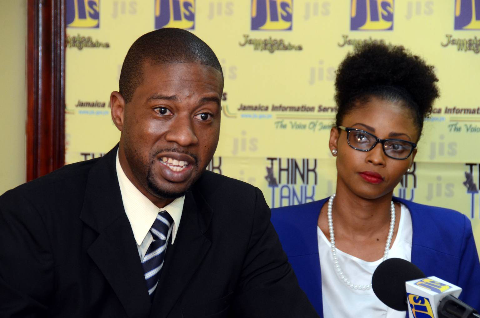 Placement Services Coordinator of the National Youth Service (NYS), Lancelot McCalla, speaking about the NYS shoe drive at a JIS ‘Think Tank’ on June 16. At right is Senior Programmes Director of the NYS, Naketa West. 