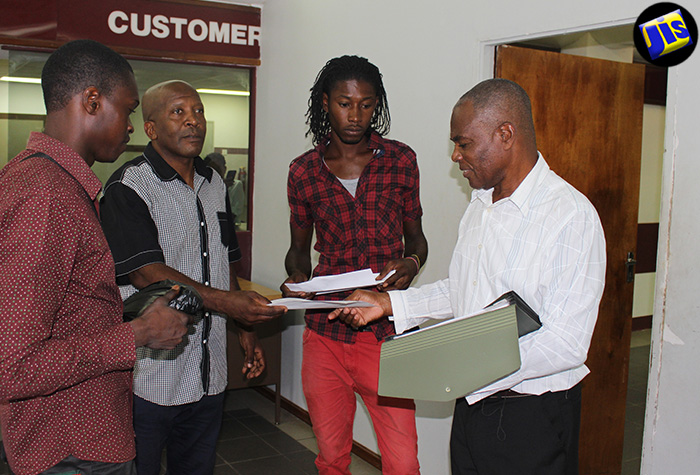 Violence interrupter and former death row inmate, Anthony Currie (right) along with other members of the St. Catherine North, Peace Management Initiative in discussion following one of their monthly meetings.  